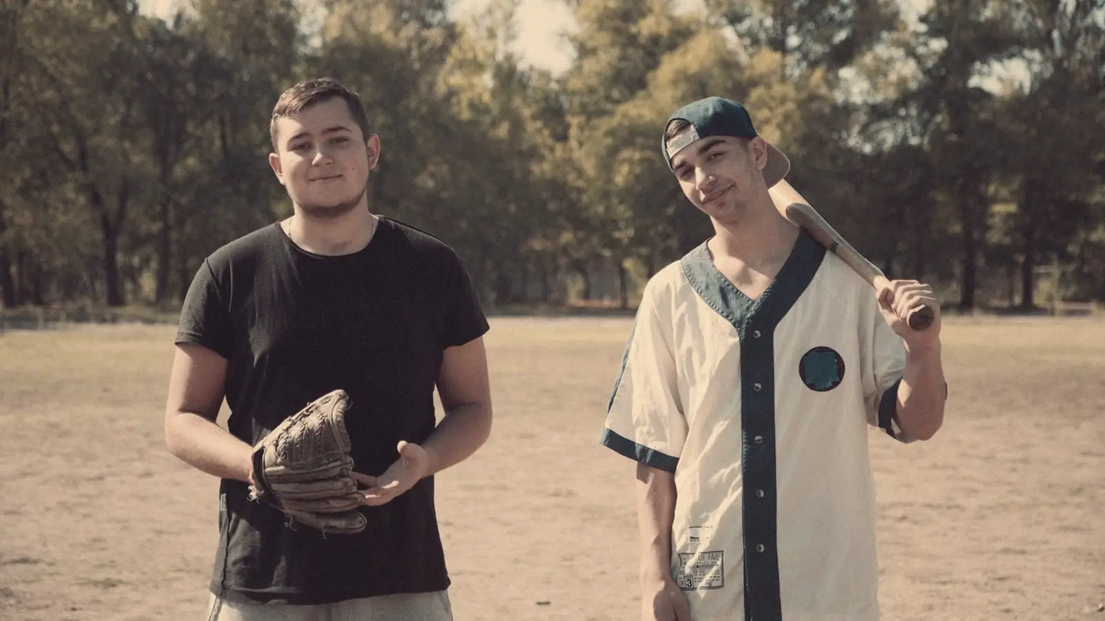 Two players in a vintage baseball jersey with glove and bat